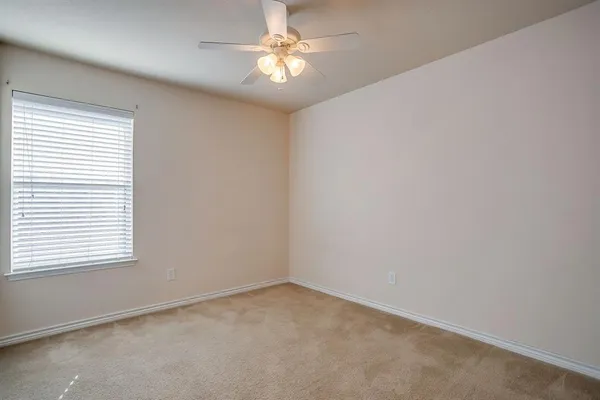an empty room with a window and a ceiling fan