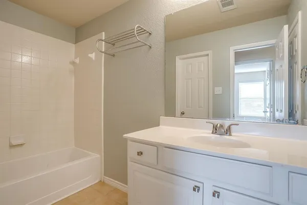 a bathroom with a sink a mirror a bathtub and a shower