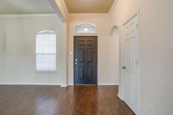 a view of a hallway with wooden floor and staircase