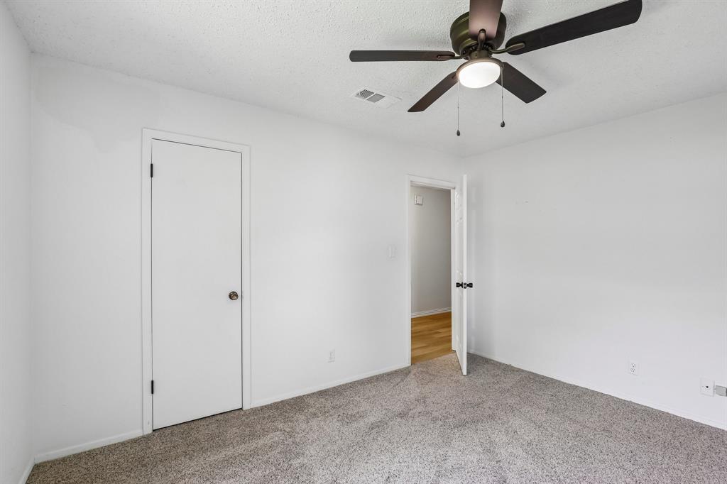1600 South Timber Court Benbrook, TX 76126 - Photo 15 of 30 Carpeted interior room with white walls, a white ceiling, and a dark bronze ceiling fan with an integrated light