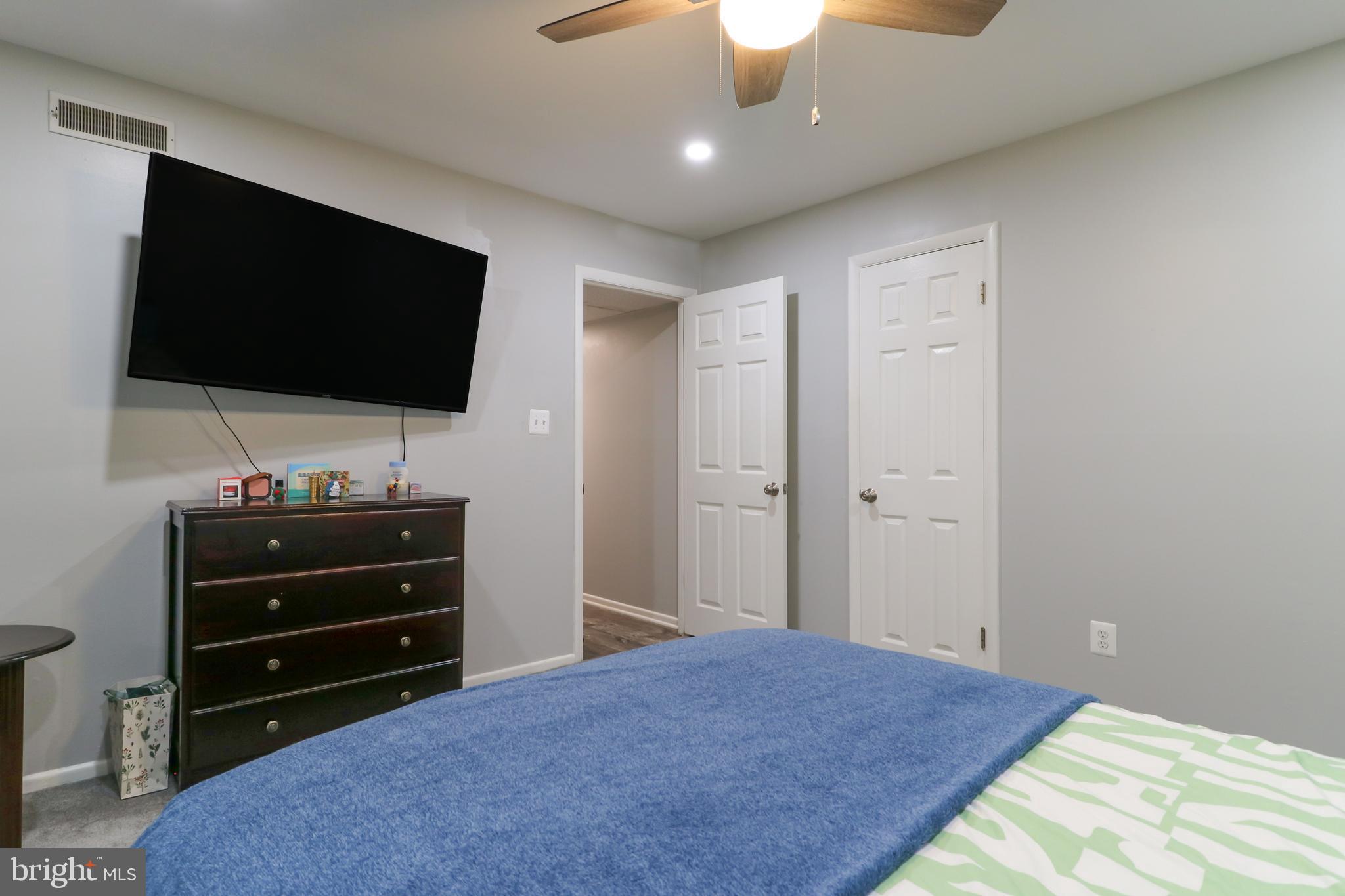 3210 South 28th Street, Unit 404 Alexandria, VA 22302 - Photo 14 of 25 a bedroom with a bed and a flat screen tv