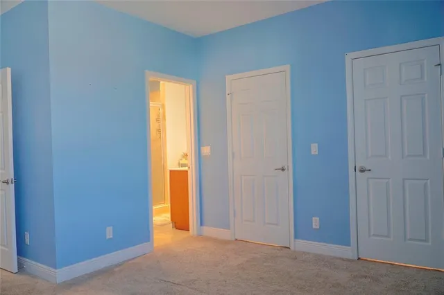 a view of an empty room with closet and a window