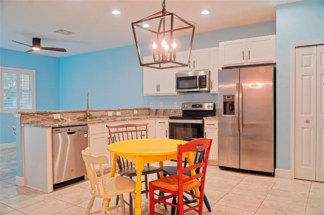 a kitchen with stainless steel appliances granite countertop a dining table and chairs