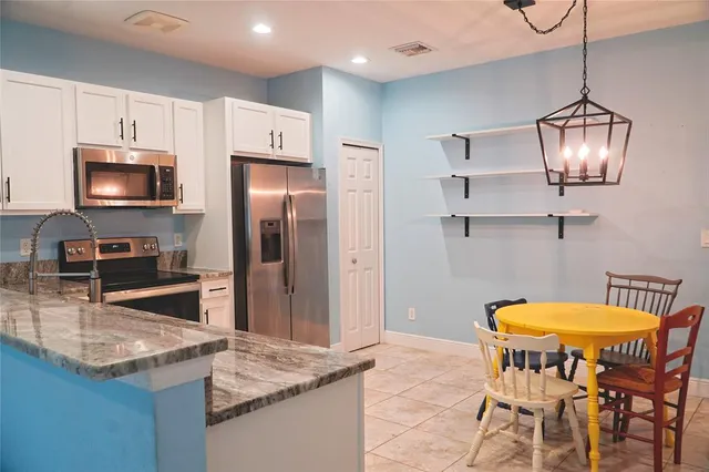 a kitchen with stainless steel appliances granite countertop a sink refrigerator and microwave