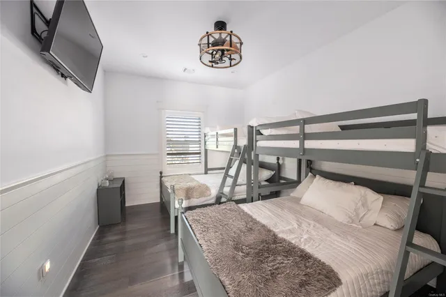 a bedroom with a bed a chandelier and a flat screen television