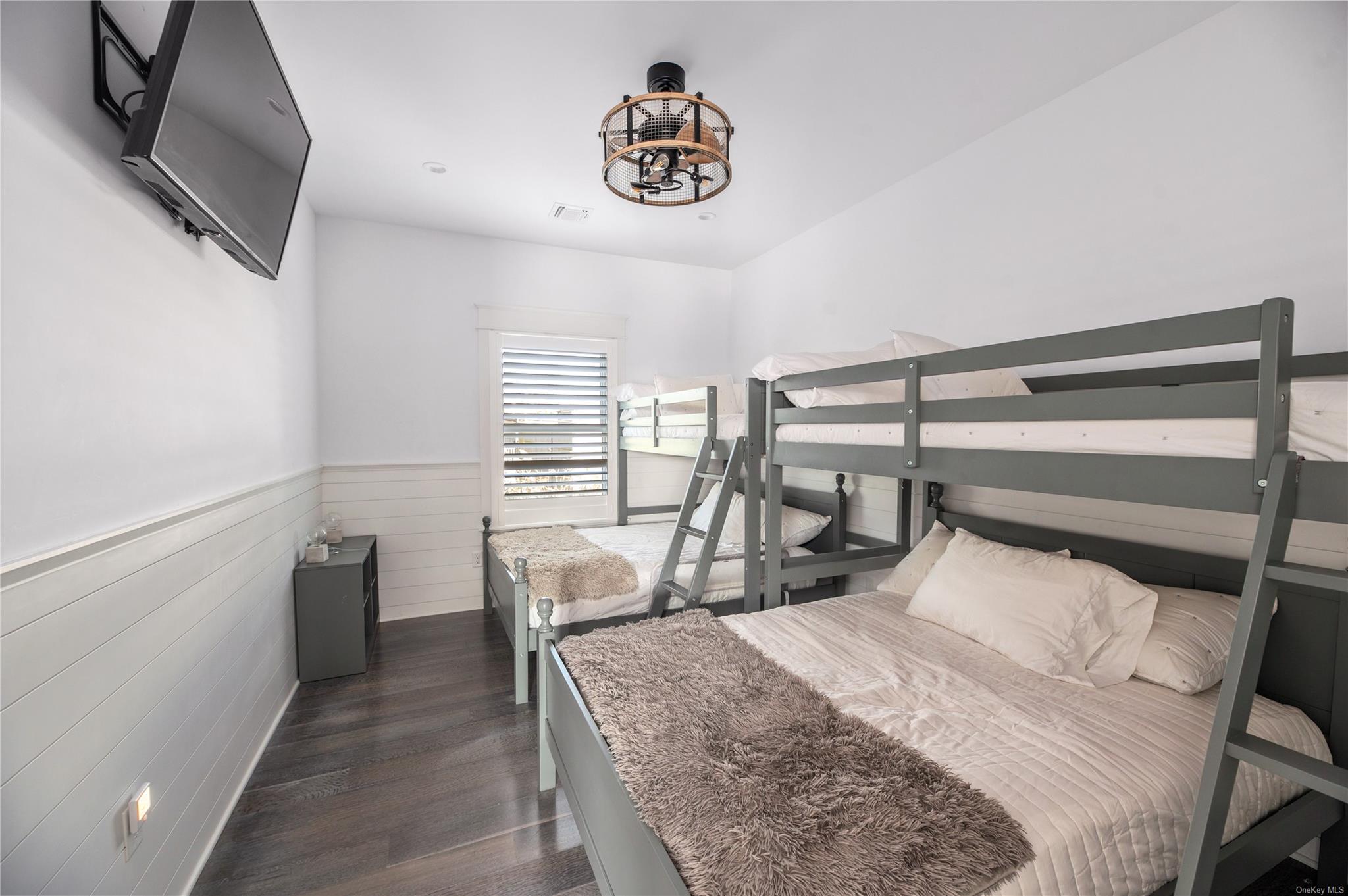 335 Surf Road Ocean Beach, NY 11770 - Photo 3 of 12 a bedroom with a bed a chandelier and a flat screen television