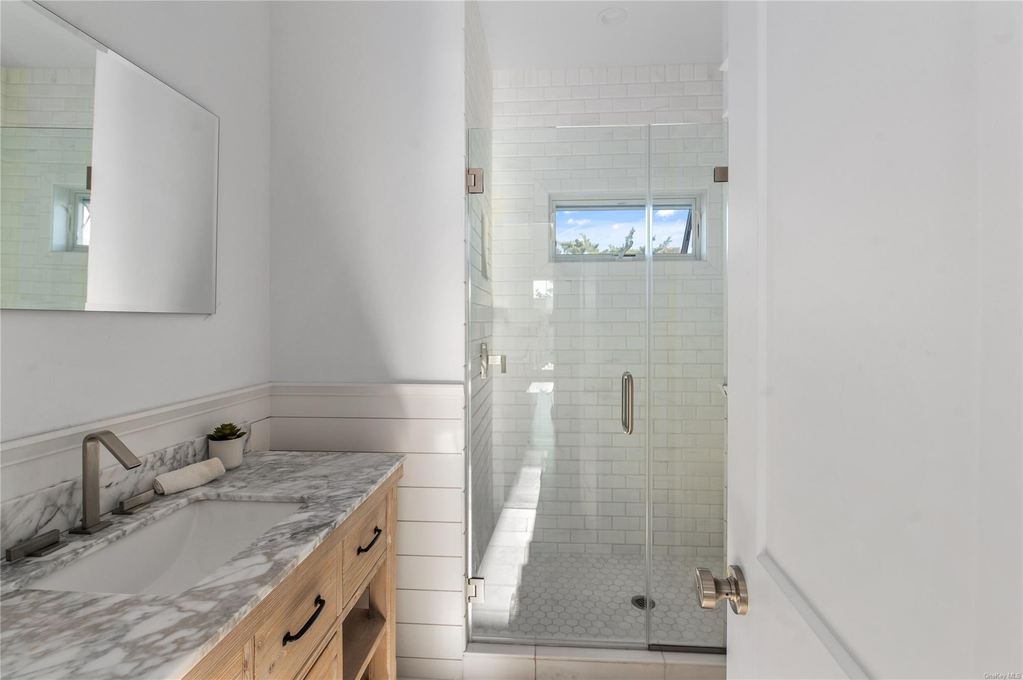 335 Surf Road Ocean Beach, NY 11770 - Photo 6 of 12 a bathroom with a granite countertop sink a shower and mirror