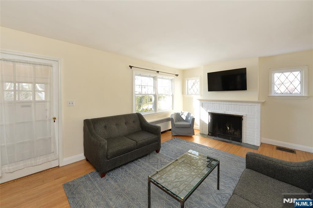 87 Grayson Place Teaneck, NJ 07666 - Photo 2 of 20 a living room with furniture a flat screen tv and a fireplace