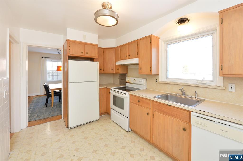 87 Grayson Place Teaneck, NJ 07666 - Photo 6 of 20 a kitchen with white cabinets and white appliances