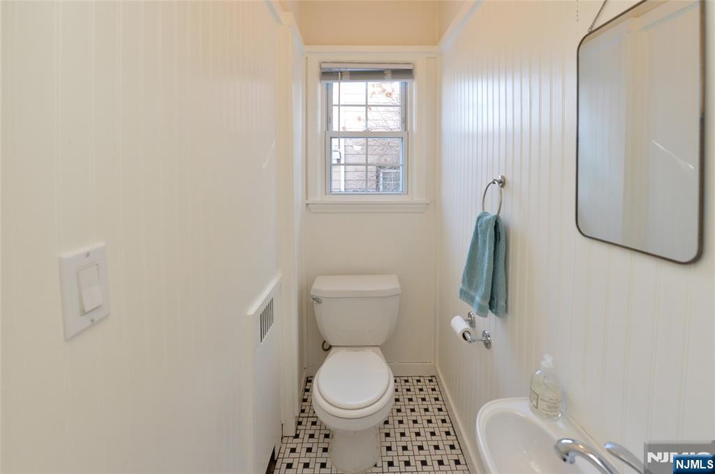 87 Grayson Place Teaneck, NJ 07666 - Photo 7 of 20 a white toilet sitting next to a bathroom sink and vanity