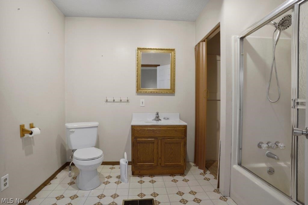 4325 Mayfair Road Uniontown, OH 44685 - Photo 21 of 35 Full bathroom with toilet, shower / bath combination with glass door, vanity, and tile flooring