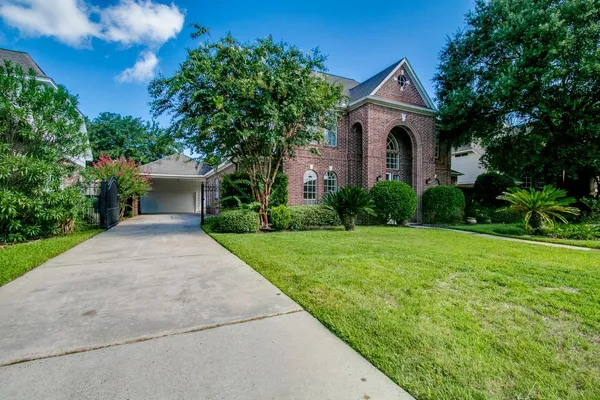 a front view of a house with garden and yard