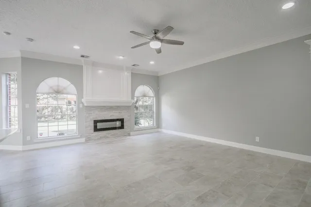 an empty room with windows and fireplace