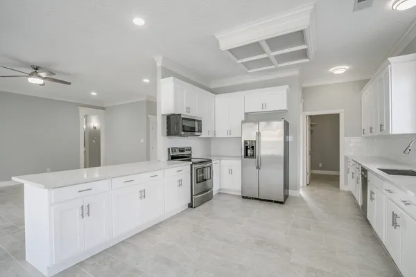 a kitchen with granite countertop white cabinets and stainless steel appliances
