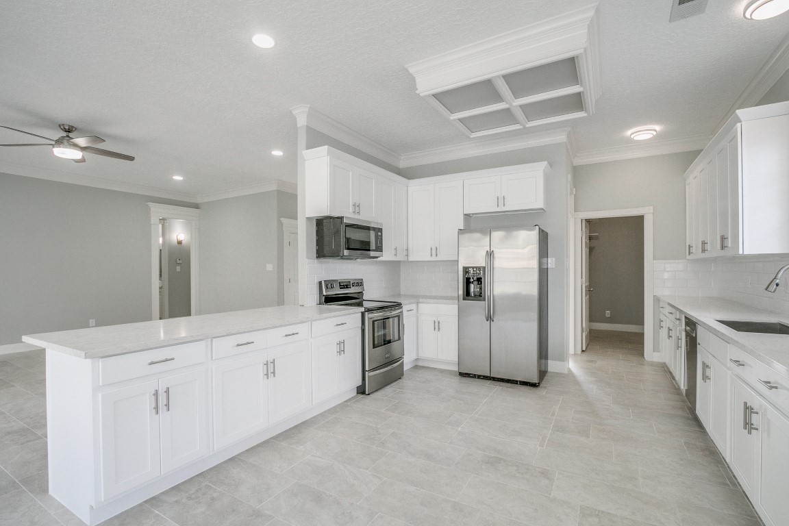 6302 Laver Love Drive Spring, TX 77379 - Photo 17 of 38 a kitchen with granite countertop white cabinets and stainless steel appliances