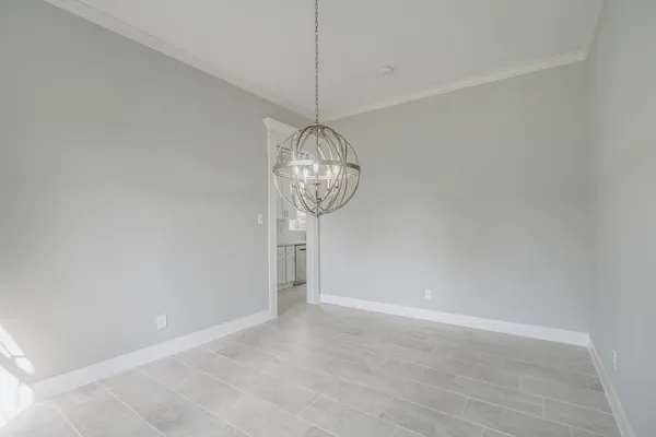 a view of a room with a chandelier fan and wooden floor