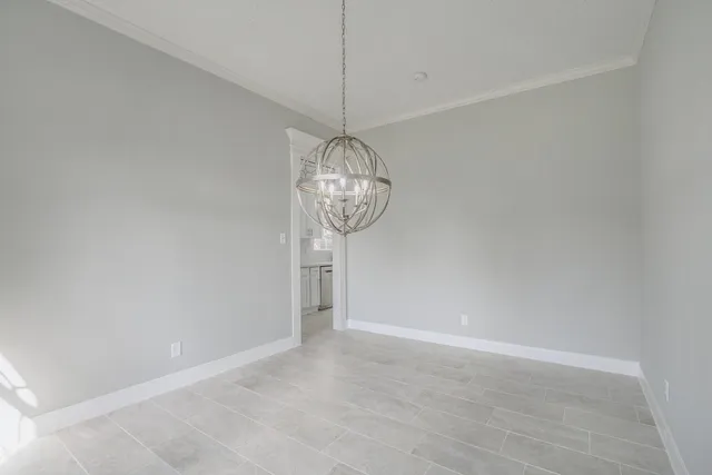 a view of a room with a chandelier fan and wooden floor