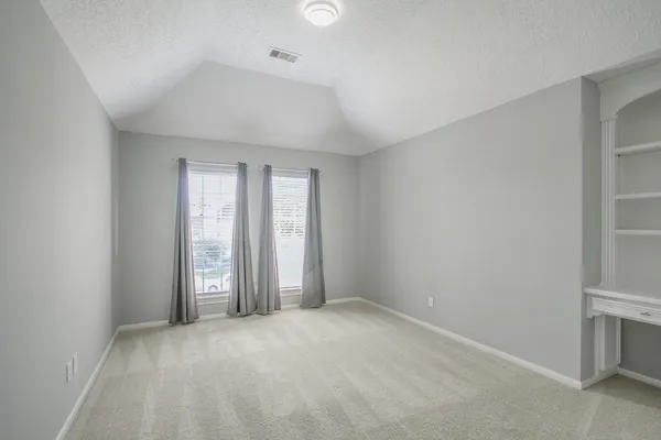 an empty room with windows and closet