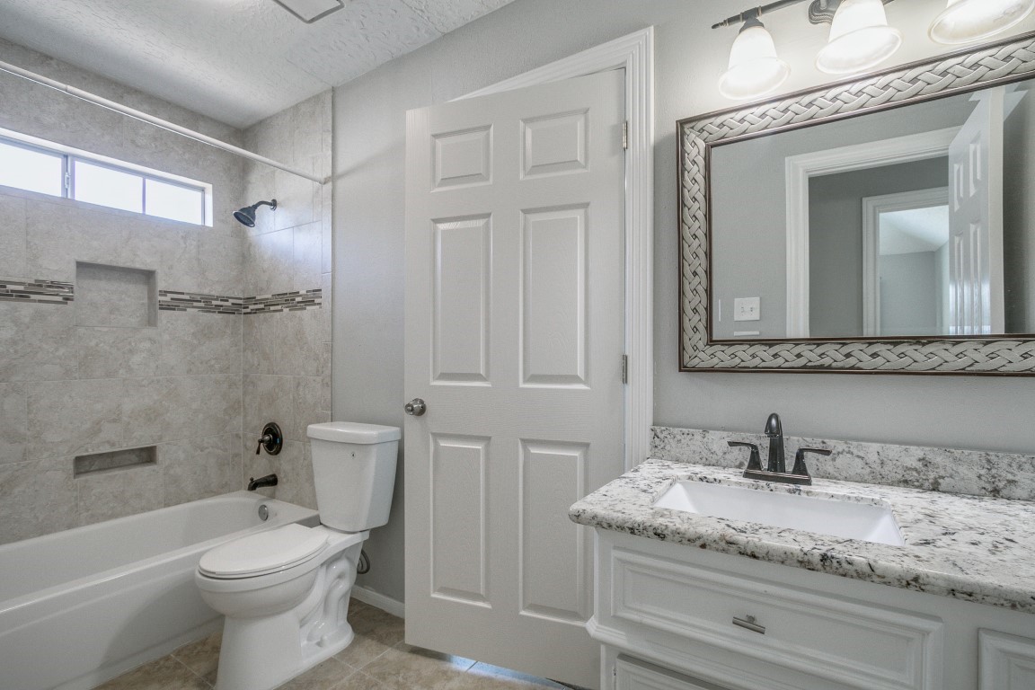 6302 Laver Love Drive Spring, TX 77379 - Photo 29 of 38 a bathroom with a granite countertop toilet a sink and bathtub