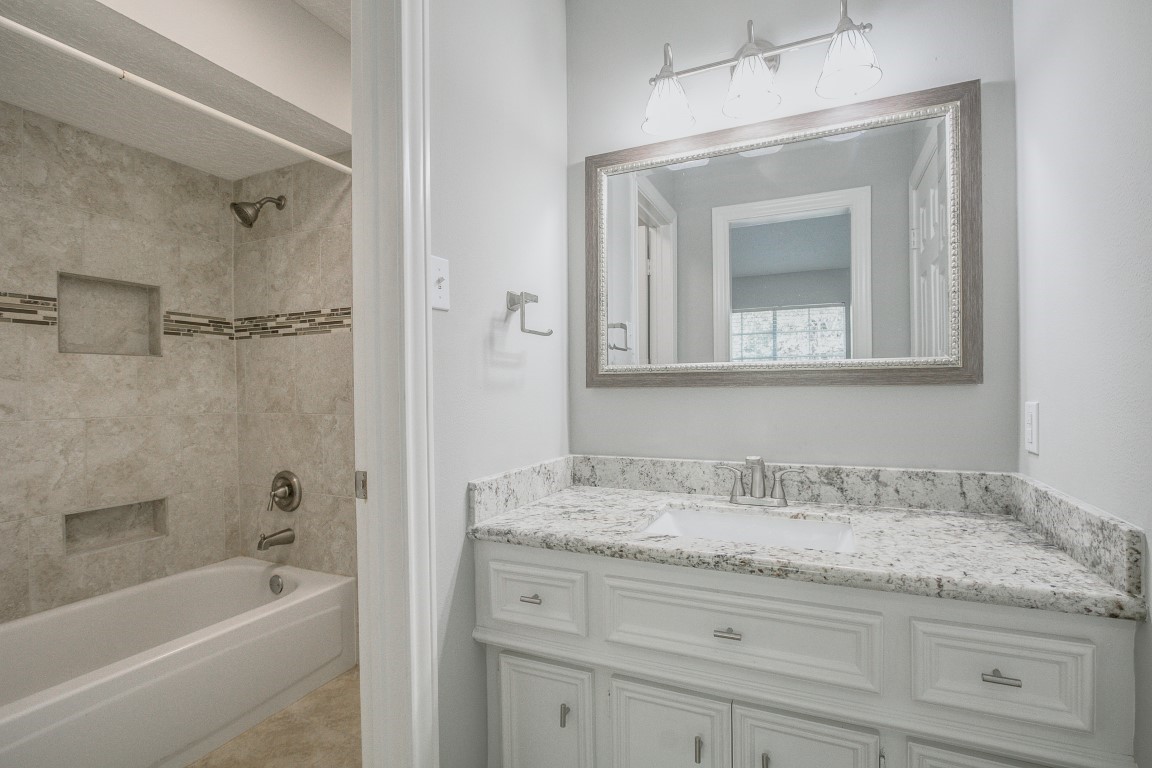 6302 Laver Love Drive Spring, TX 77379 - Photo 32 of 38 a bathroom with a granite countertop bathtub shower sink vanity and mirror