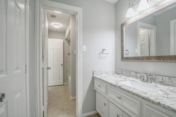 a bathroom with a granite countertop sink and a mirror