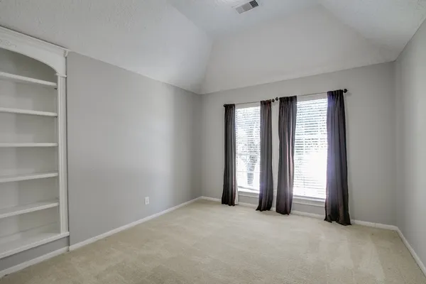 an empty room with windows and closet