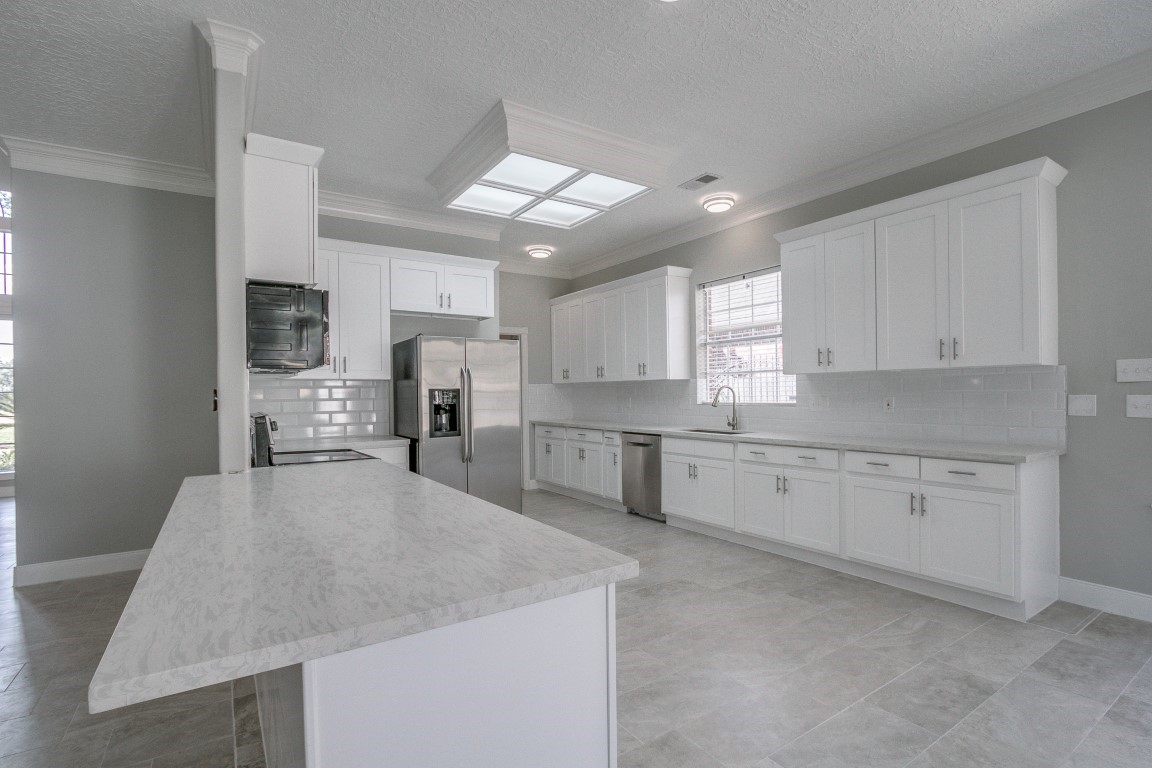 6302 Laver Love Drive Spring, TX 77379 - Photo 36 of 38 a large kitchen with granite countertop a large counter top appliances and cabinets