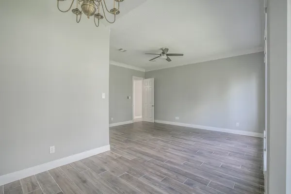 a view of an empty room with wooden floor