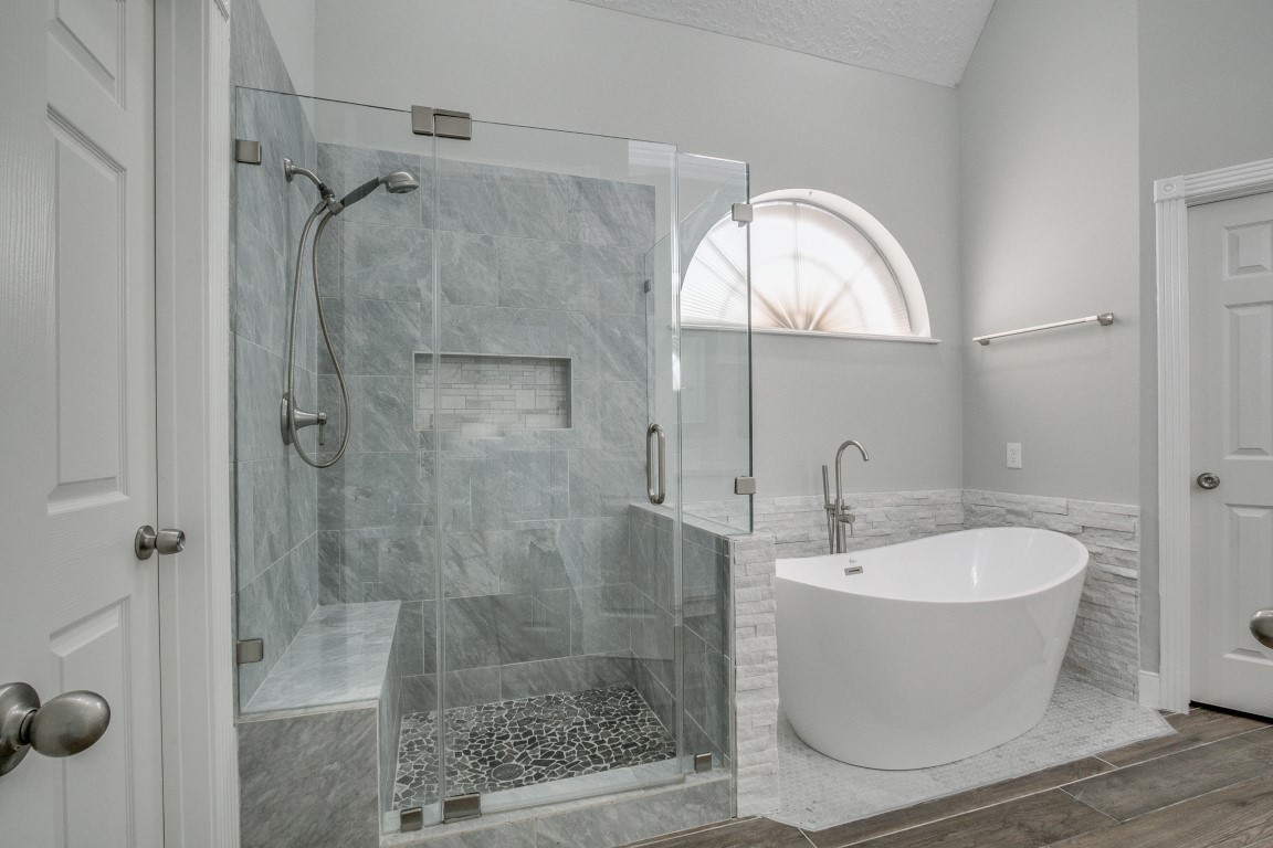 6302 Laver Love Drive Spring, TX 77379 - Photo 9 of 38 a bathroom with a white bath tub a mirror and a shower