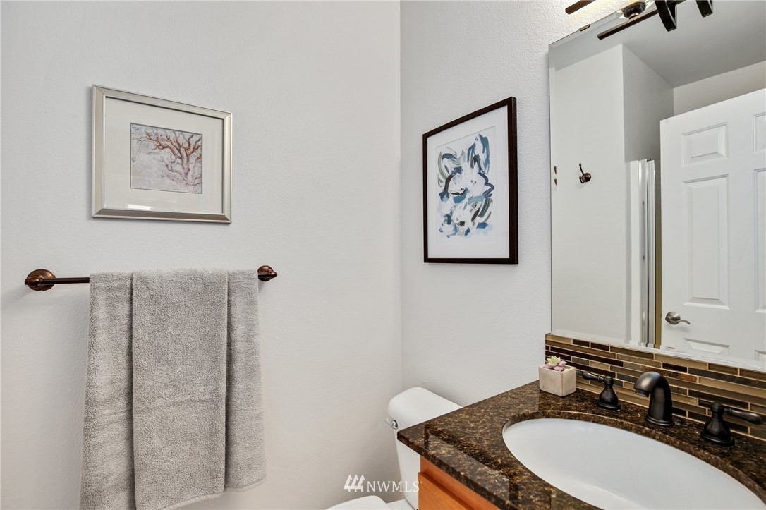17264 Southeast 185th Street Renton, WA 98058 - Photo 19 of 40 a bathroom with a granite countertop sink a mirror and a toilet