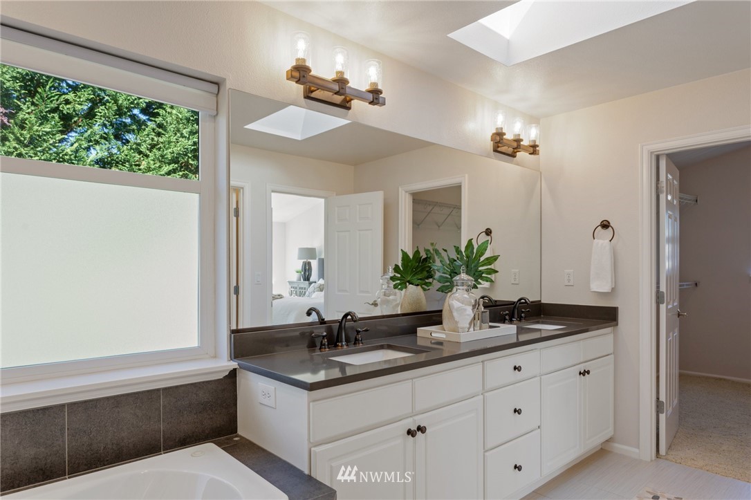 17264 Southeast 185th Street Renton, WA 98058 - Photo 27 of 40 a bathroom with a granite countertop sink a large mirror and a window
