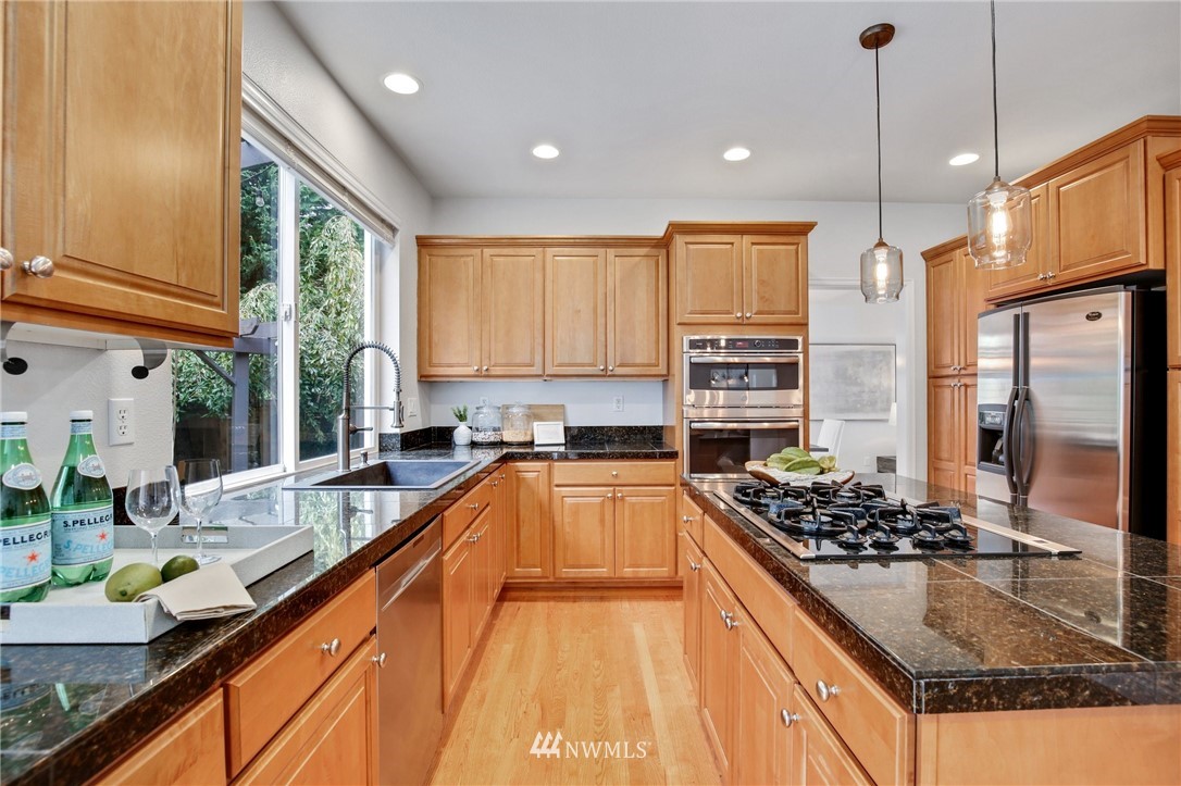 17264 Southeast 185th Street Renton, WA 98058 - Photo 7 of 40 a kitchen with stainless steel appliances granite countertop a sink stove and refrigerator