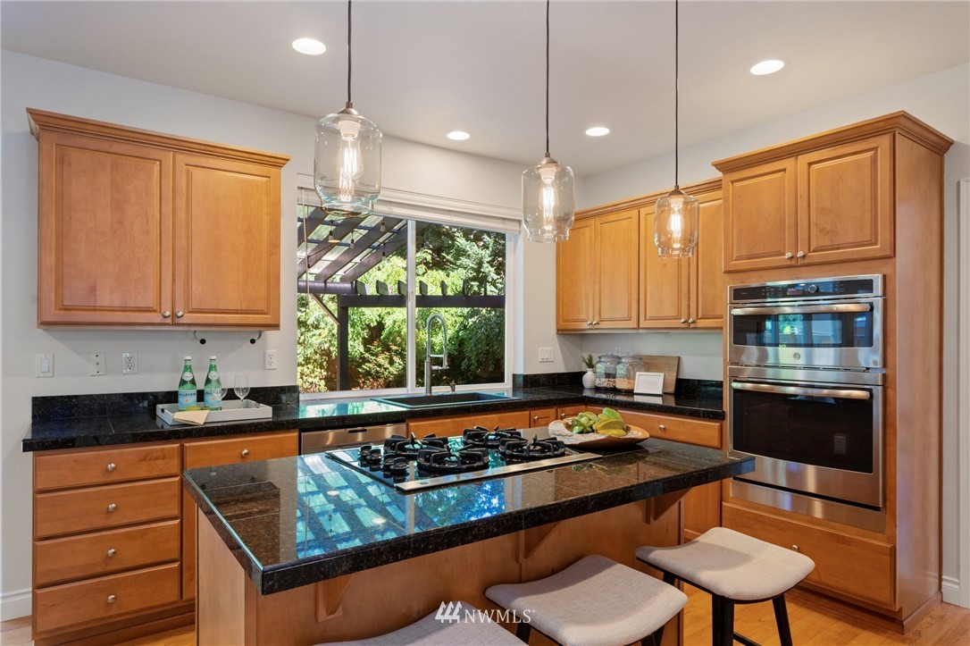17264 Southeast 185th Street Renton, WA 98058 - Photo 8 of 40 a kitchen with stainless steel appliances granite countertop a stove a sink and a refrigerator