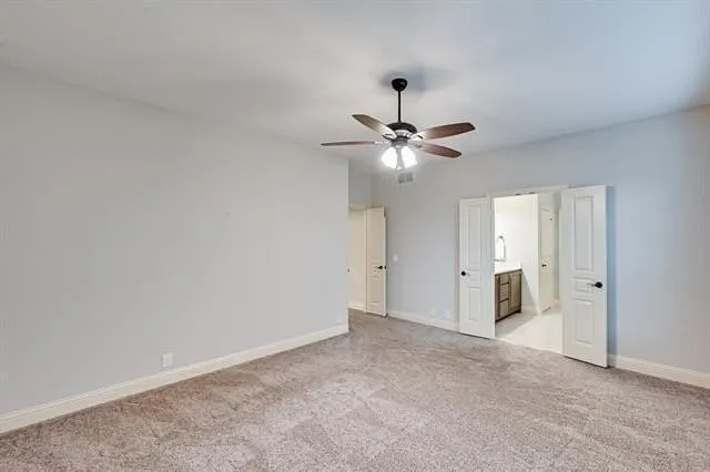 a view of an empty room with a chandelier fan