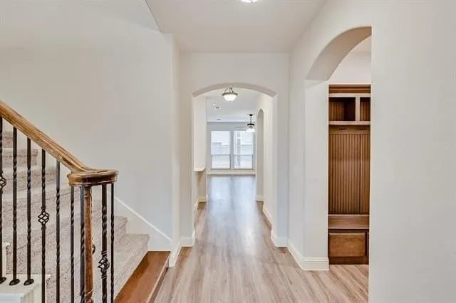 a view of a hallway with wooden floor and staircase