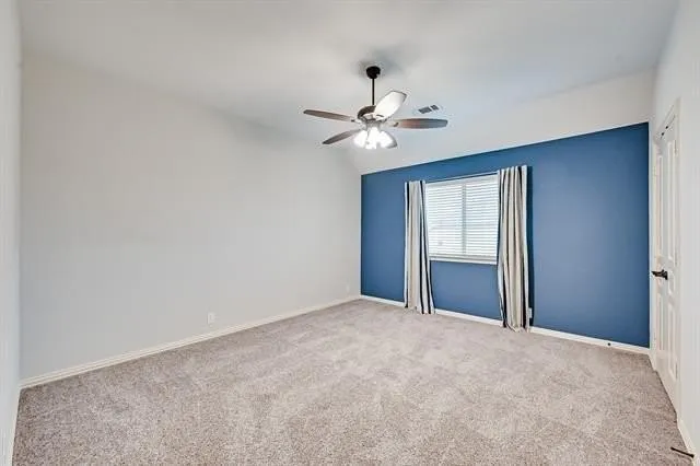 a view of an empty room with a ceiling fan