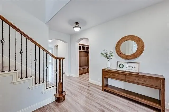 a view of a hallway with wooden floor and staircase