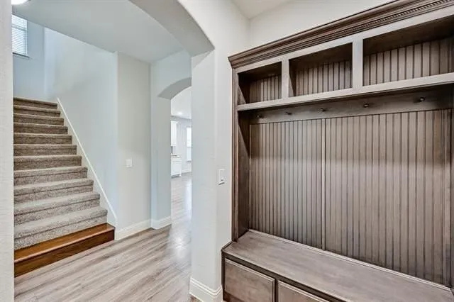 a view of a hallway with wooden floor and entryway