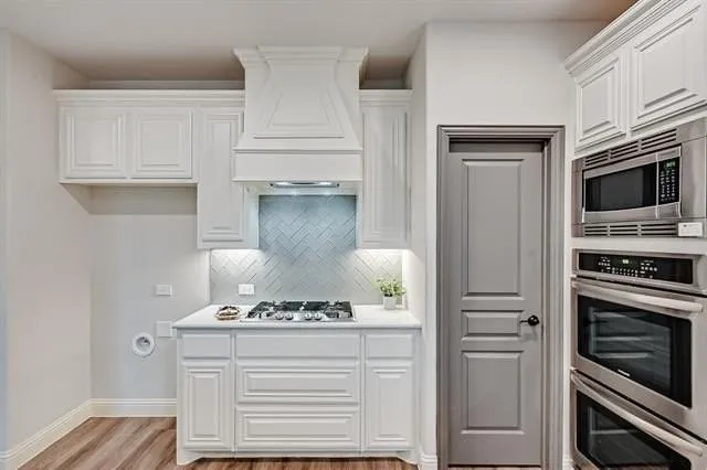 a kitchen with a stove and white cabinets