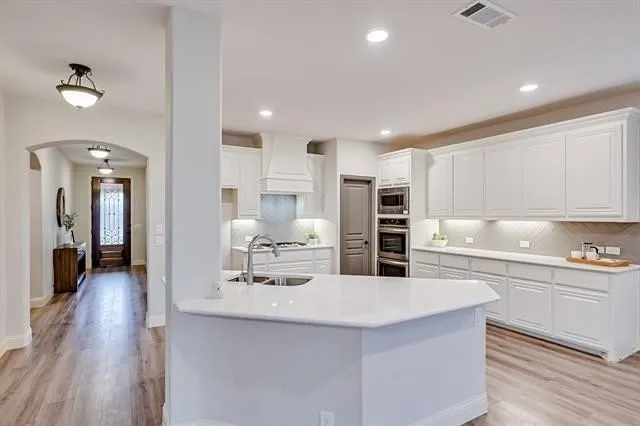 a kitchen with stainless steel appliances kitchen island granite countertop a sink and cabinets