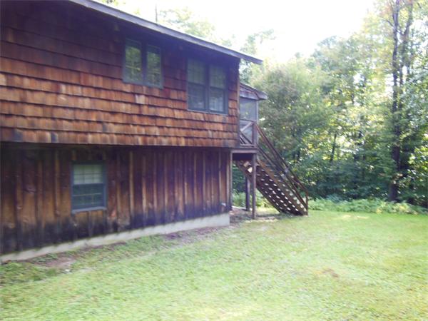 76 Slope Road Tolland, MA 01034 - Photo 3 of 11 a view of a house with a yard and wooden fence