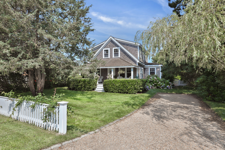 a front view of a house with yard and green space