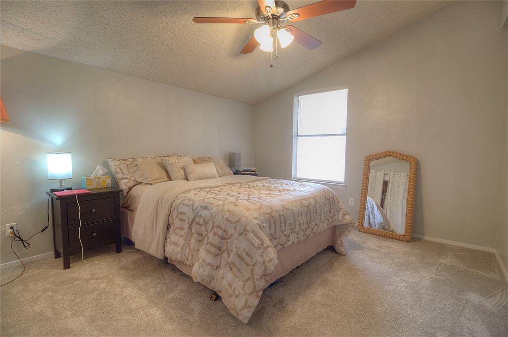 12818 Midway Road, Unit 2068 Dallas, TX 75244 - Photo 12 of 12 a spacious bedroom with a bed and ceiling fan