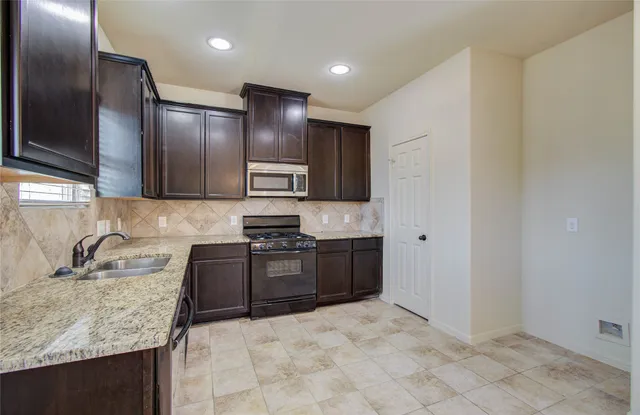 a kitchen with stainless steel appliances granite countertop a stove and a sink