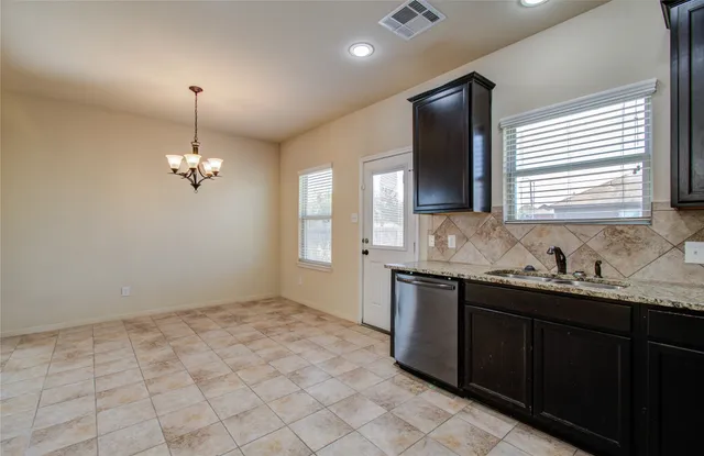 a view of an empty room and chandelier fan