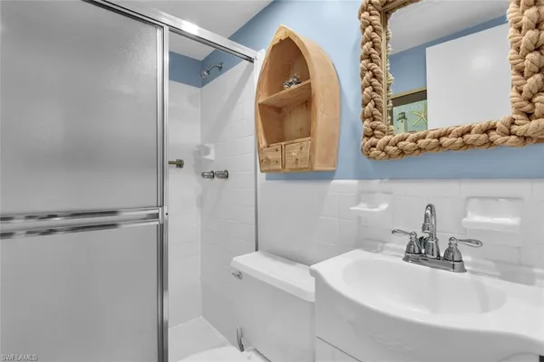 a bathroom with a sink a mirror and a shower