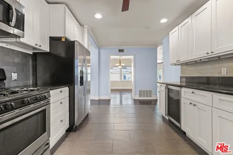 a kitchen with stainless steel appliances a stove refrigerator and cabinets