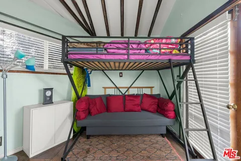 a bed room with a bed a couch and a window