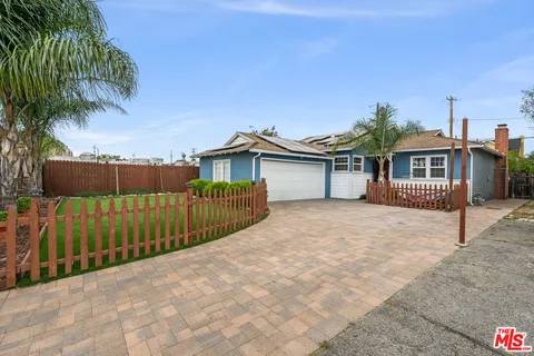 a view of a house with a wooden deck and a yard