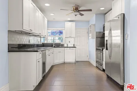 a kitchen with a sink refrigerator and cabinets